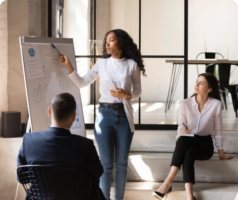 Woman presenting at office meeting with colleagues.