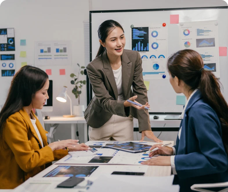 Women in a business meeting discussing charts.